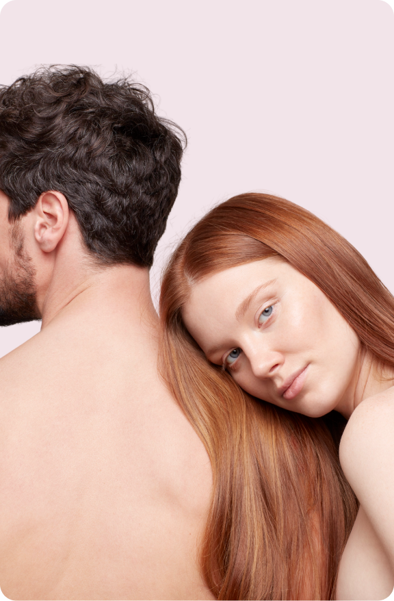 Woman with long, thick hair leans on the shoulder of a man